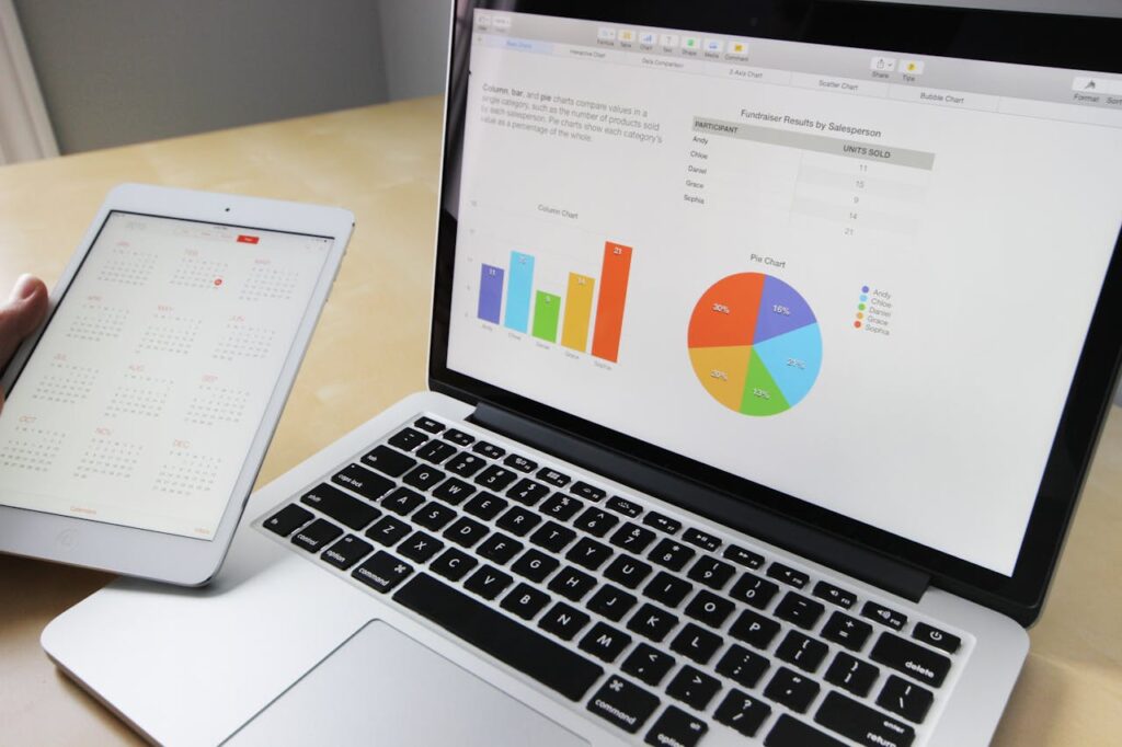 pexels photo 265087 Laptop displaying charts and graphs with tablet calendar for data analysis and planning.
